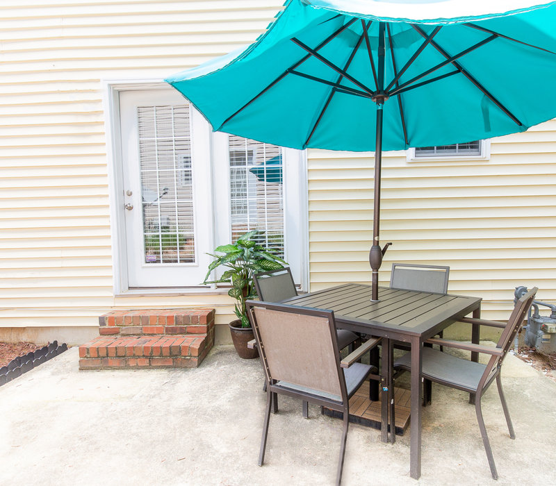 Outdoor patio with teal umbrella and dining set